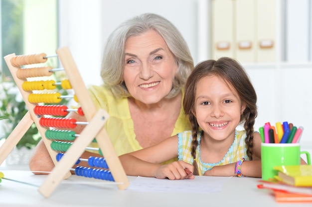 Portrait of a grandmother and granddaughter counting at home