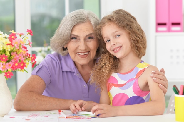 Portrait of grandmother and granddaughter drawing together