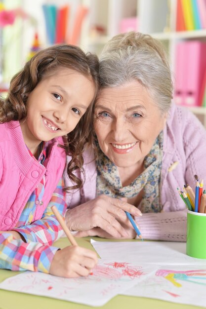 Portrait of grandmother and granddaughter drawing together