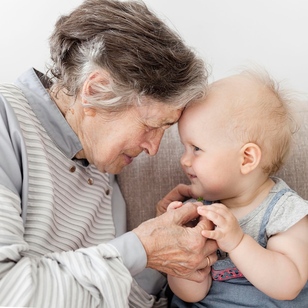 Portrait of grandmother hugging playing with baby