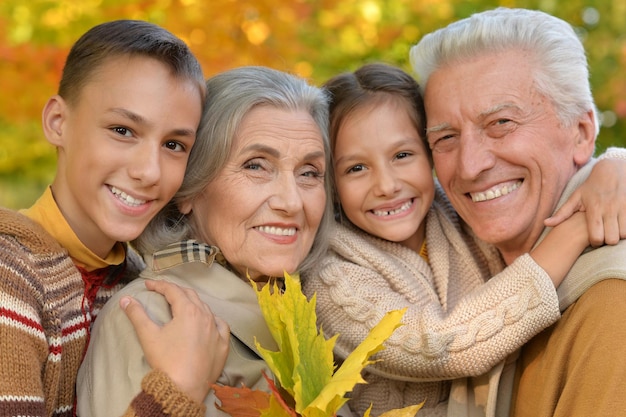 Portrait of grandparents with grandchildren posing outdoors in autumn