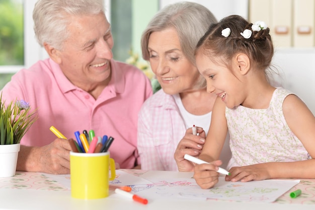 Portrait of a grandparents with their granddaughter drawing together