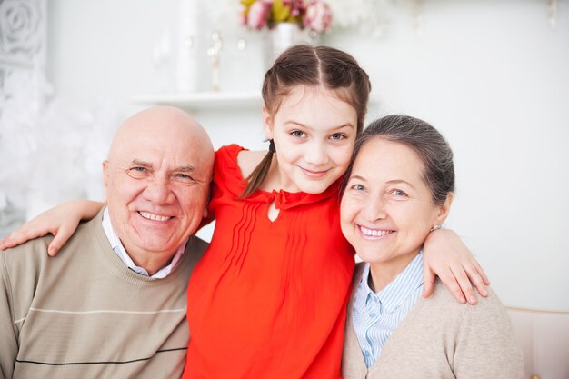 Portrait of grandparents with their granddaughter.