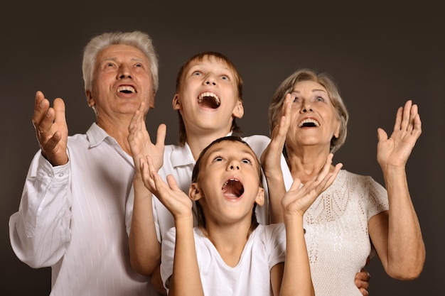 Foto ritratto di nipoti con i nonni su sfondo grigio