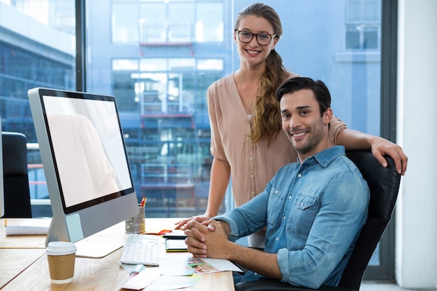 Portrait of graphic designer at desk with colleague