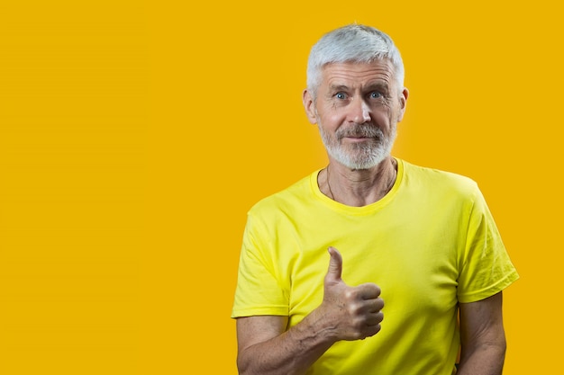 Portrait of a gray-haired man with a beard shows gesture good on blue background