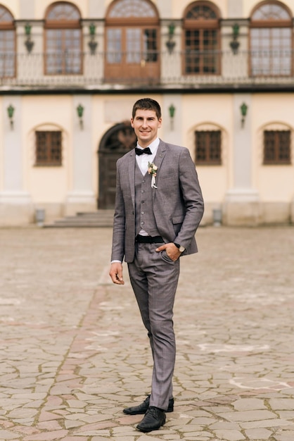 Photo portrait of the groom on the background of an old building