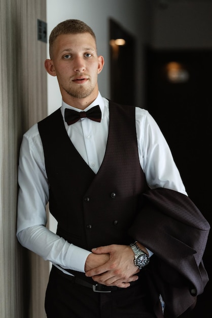 Portrait of the groom in a brown threepiece suit