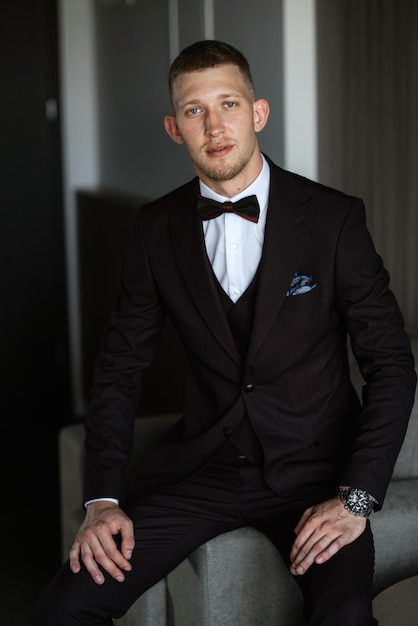 Portrait of the groom in a brown threepiece suit