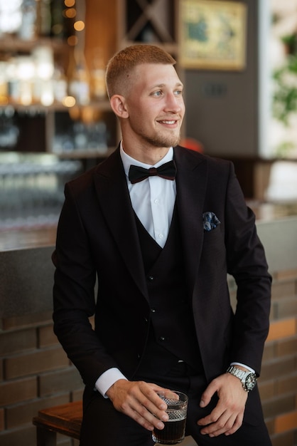 Portrait of the groom in a brown threepiece suit