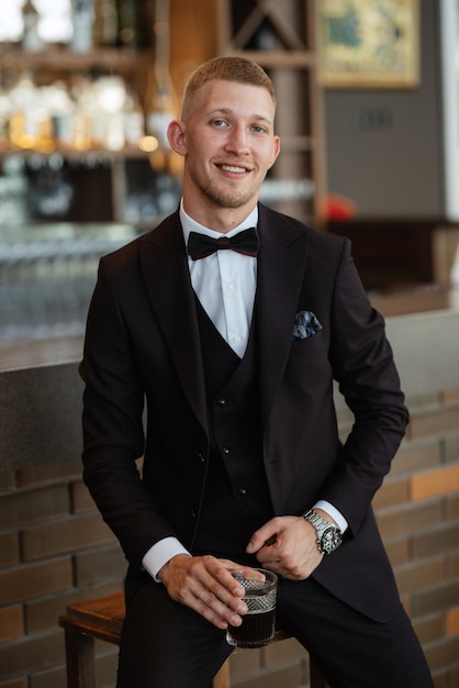 Portrait of the groom in a brown threepiece suit