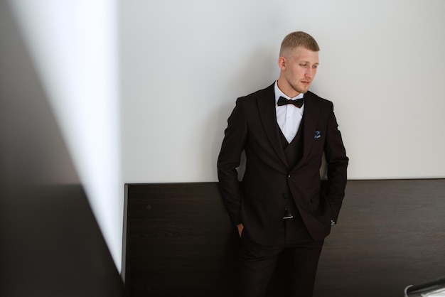 Portrait of the groom in a brown threepiece suit