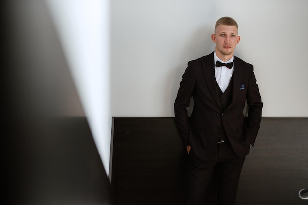 Portrait of the groom in a brown threepiece suit