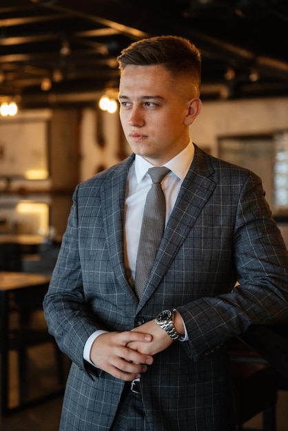 Portrait of a groom in a gray plaid suit with a tie