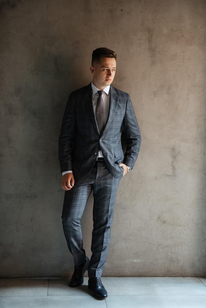 Portrait of a groom in a gray plaid suit with a tie