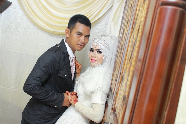 Photo portrait of groom holding hands of beautiful bride during wedding