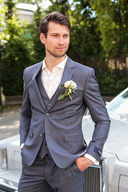 Photo portrait of groom standing near retro car. wedding.