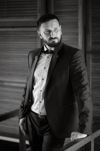 Portrait of a groom with a beard in a blue suit