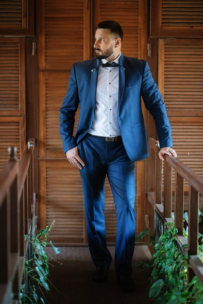 Portrait of a groom with a beard in a blue suit