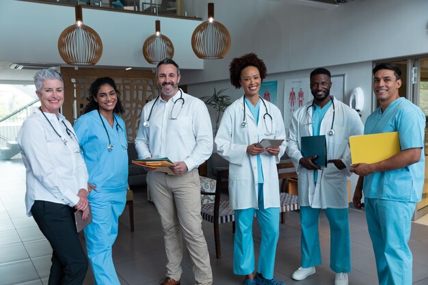 Photo portrait of group of diverse male and female doctors standing in hospital corridor smiling to camera