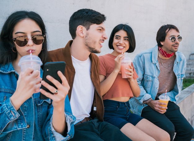 Portrait of a group of friends having fun together and enjoying good time while drinking fresh fruit juice. Lifestyle and friendship concept.