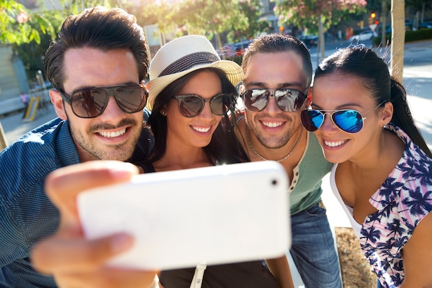 Portrait of group friends taking photos with a smartphone.