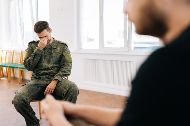 portrait of group male soldiers in camouflage uniform talking sitting in circle during ptsd group