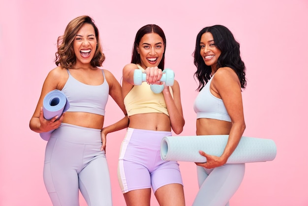 Photo portrait group and women with fitness smile and pilates training on a pink studio background funny girls and friends with exercise self care and health with wellness meditation and yoga mat