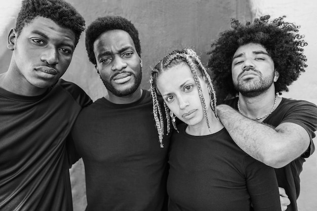 Photo portrait of group of young african people looking at camera outdoor focus on girl face black and white editing