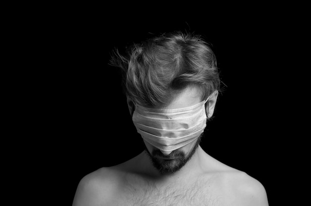 Portrait of a guy on a black background, a mask on his eyes