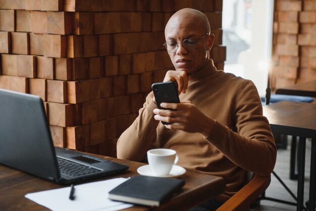 Portrait of a guy using mobile phone and laptop