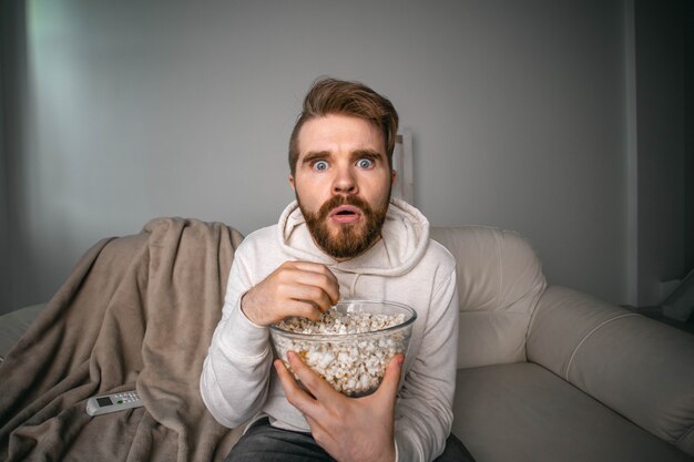 Portrait of guy watching TV series online. Online cinema and video streaming service concept.