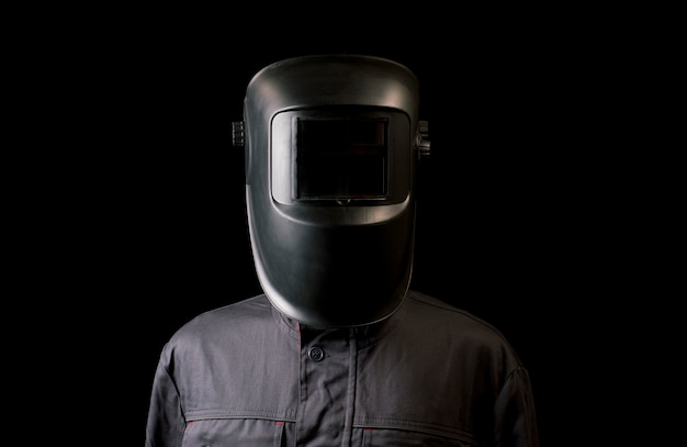 Portrait of a guy in a welding mask on a black