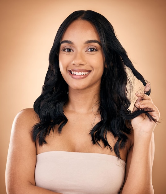 Portrait hair and aesthetic with a model woman in studio on a brown background for shampoo treatment Beauty salon and smile with a confident young person looking natural after cosmetic haircare