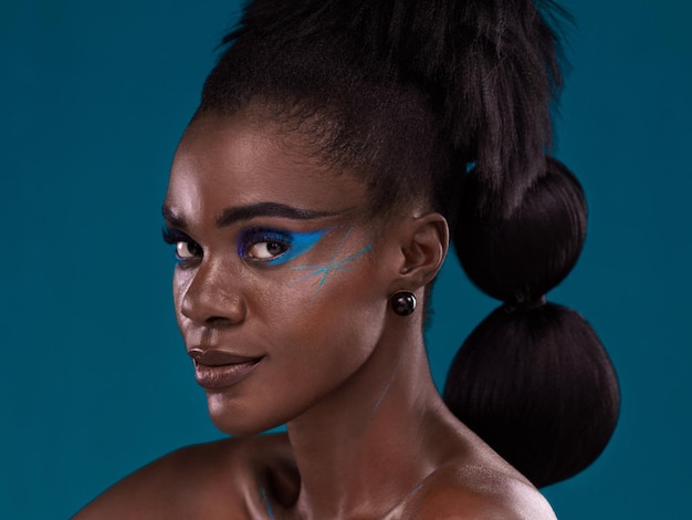 Portrait hair and makeup with an african woman in studio on a blue background for beauty or cosmetics face haircare and fashion with an attractive young female model posing for natural style