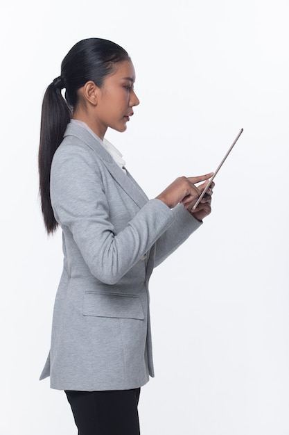 Portrait half body Snap Figure, Asian Business Woman Stand in Gray Formal proper Suit black pants and shoes, studio lighting white background isolated, Lawyer Boss touch tablet success work smile glad