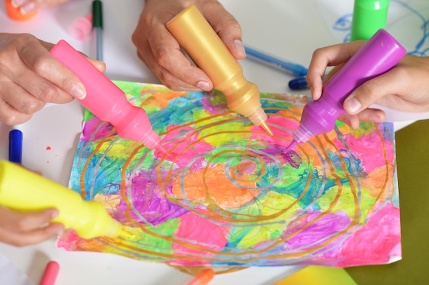 Photo portrait of hands of people painting colorful picture