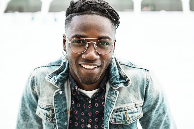 Portrait of handsome African American man smiling in the street with modern glasses