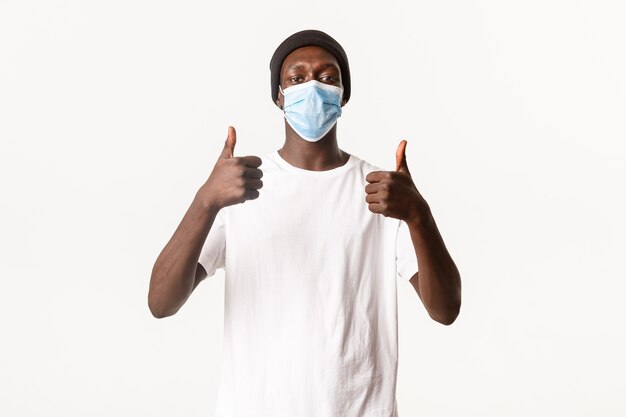 Portrait of handsome african-american young man in beanie and medical mask