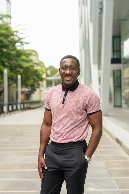 Portrait of handsome African businessman outdoors in city