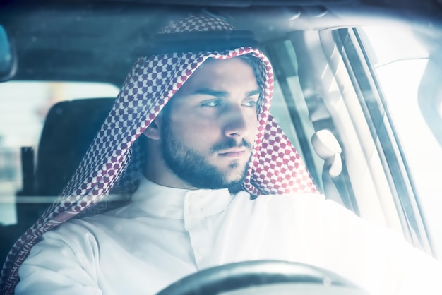 Портрет красивого арабского мужчины за рулем автомобиля