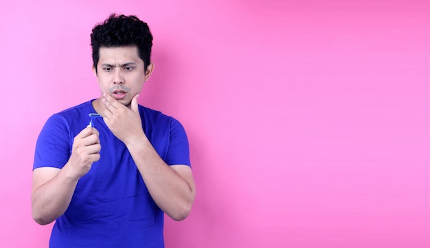 Portrait handsome asia man with a shaving on pink background in studio