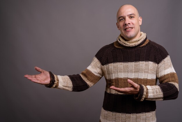 Portrait of handsome bald man against gray background