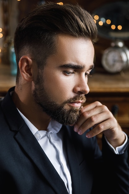 Portrait of handsome bearded man wearing black classic suit