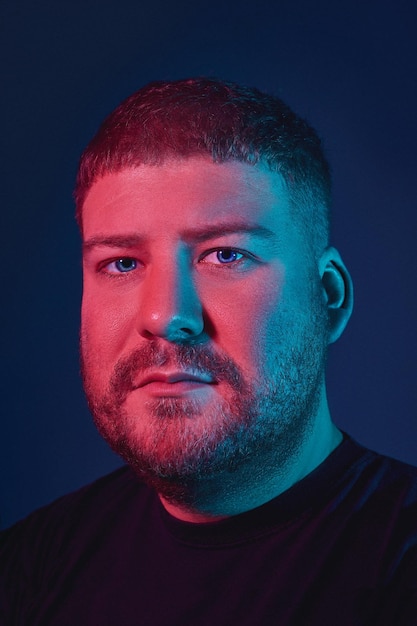 Photo portrait of a handsome bearded young man in a black sweater looking at the camera