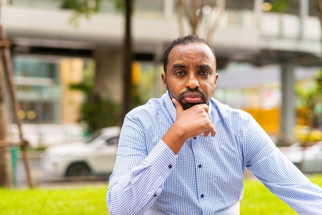 Portrait of handsome black businessman in city