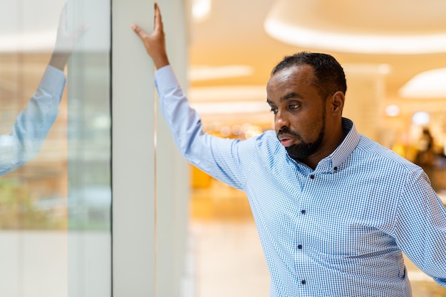 Portrait of handsome black man looking through window