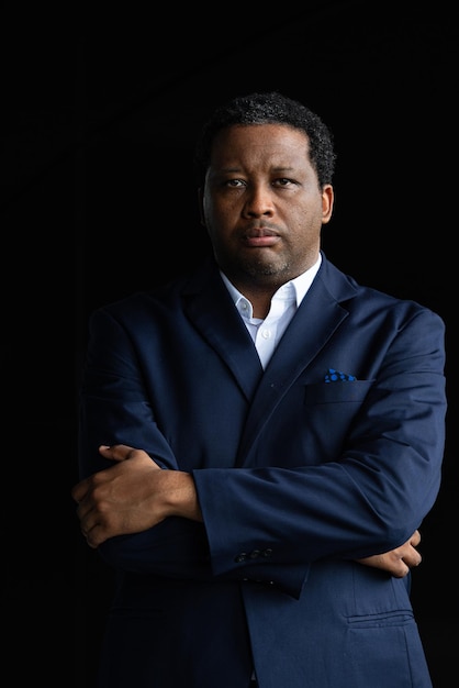 Portrait of handsome black man wearing suit with arms crossed