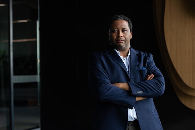 Portrait of handsome black man wearing suit with arms crossed