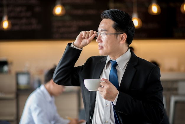 カフェでコーヒーを飲むハンサムなビジネスマンの肖像